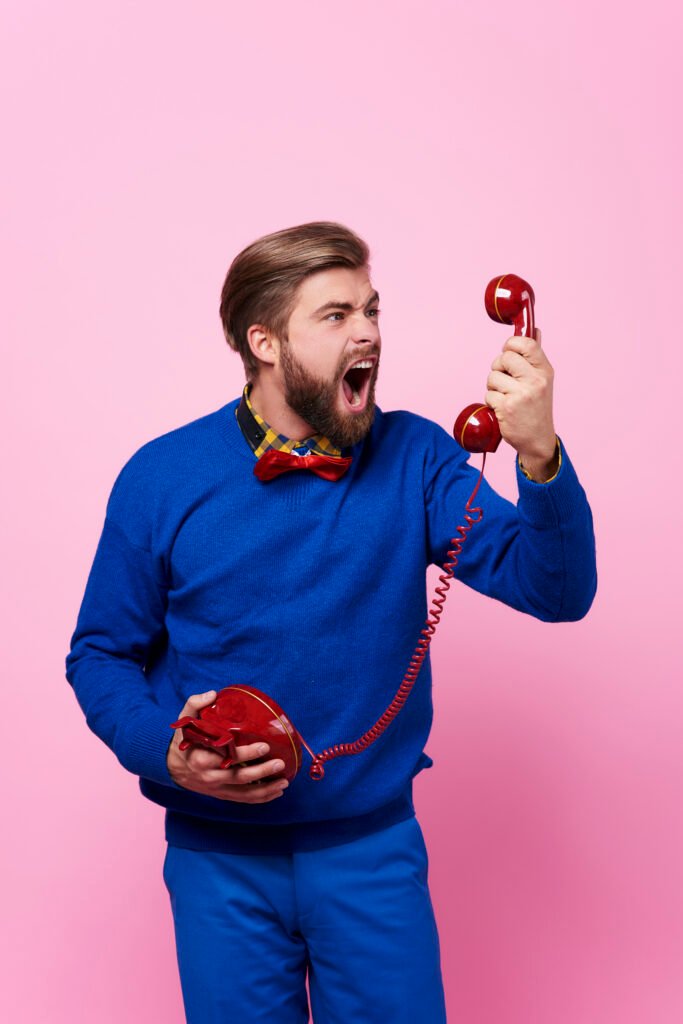 Furious man arguing on a phone call, representing the challenges Pulse Digital solves with effective communication and customer service.