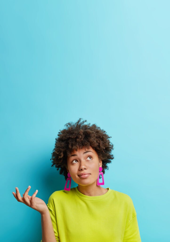 Vertical shot of a doubtful Afro American woman looking confused, embodying the decision-making process in digital strategy discussions.